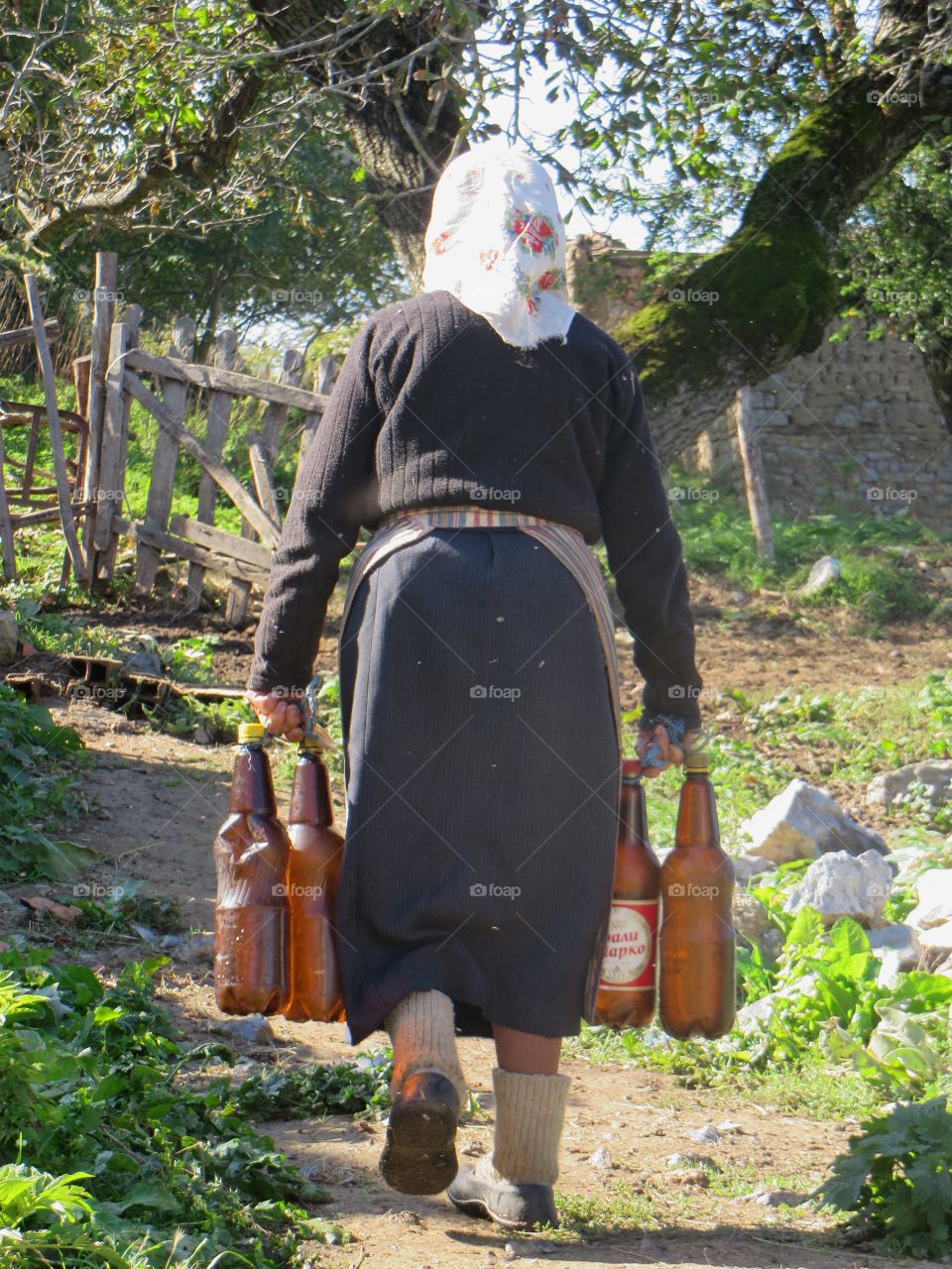 Woman getting water from well in small village in Macedonia 