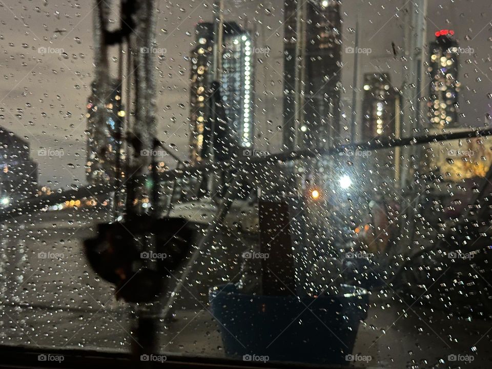 Raindrops on the window of “Salvation”, the “28 ft 1969 Luhrs” cabin cruiser at “Newtown Creek” in LIC, Queens we call home are illuminated by the lights of NYC to make them appear like a glittering curtain. 2023. Hypnotic Productions