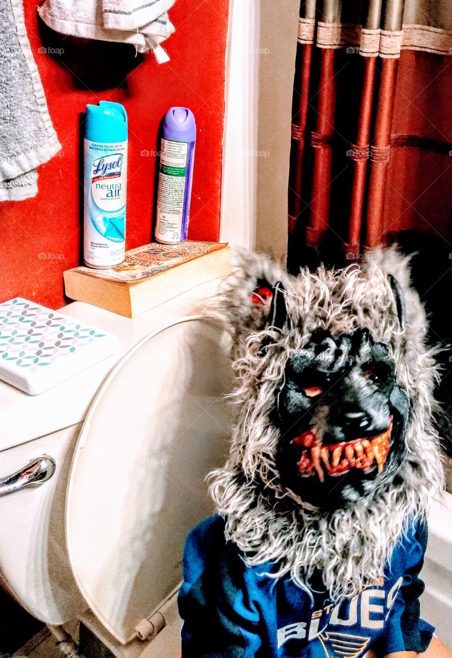 child wearing a werewolf mask in the restroom