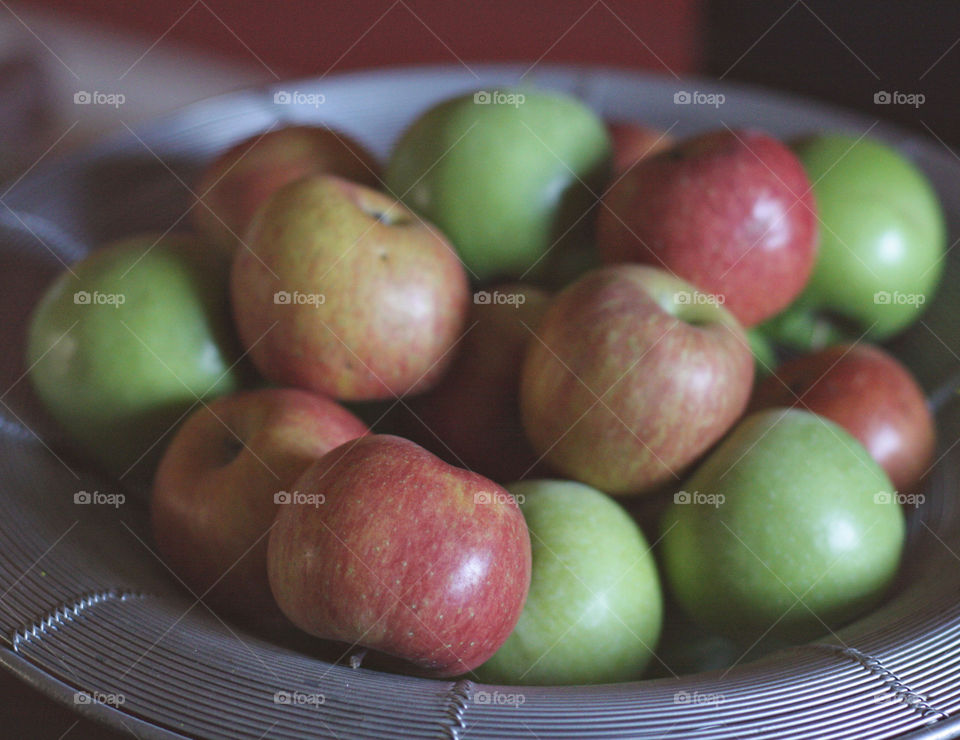 Red and green apples in silver basket