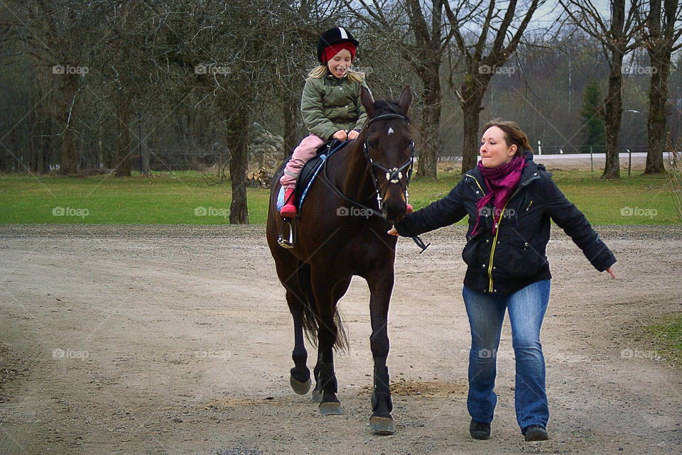 Mother training her child riding the horse