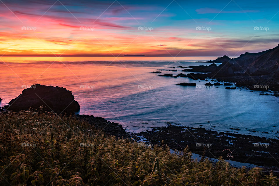 A bright and colourful sunset over Hartland Quay.