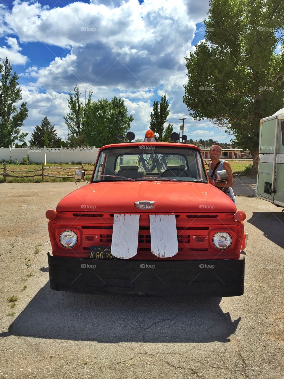 Man leaning near the red car