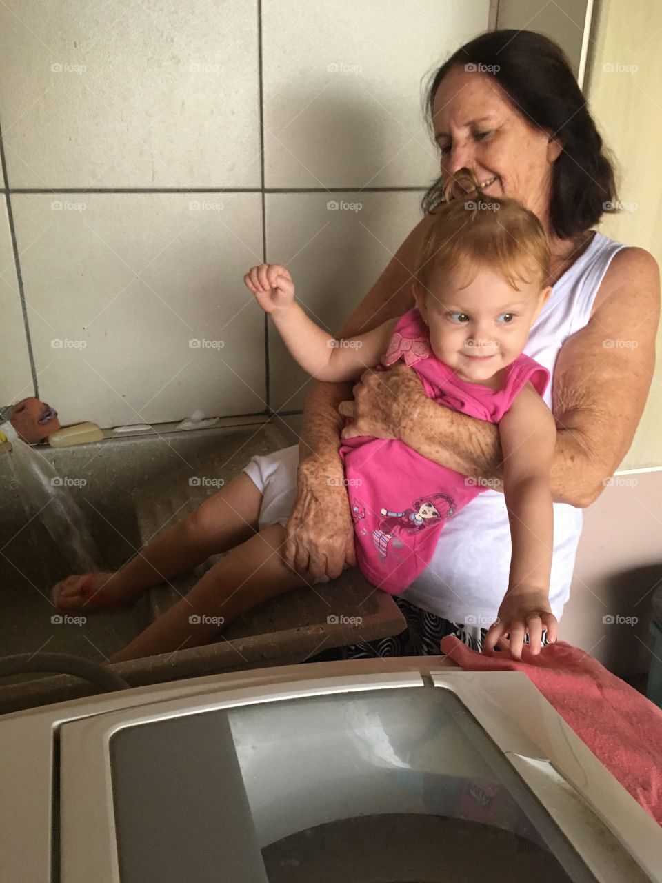 A alegria em tomar banho num tanque com a vovó! Criança adora essas coisas... viva a vida!
