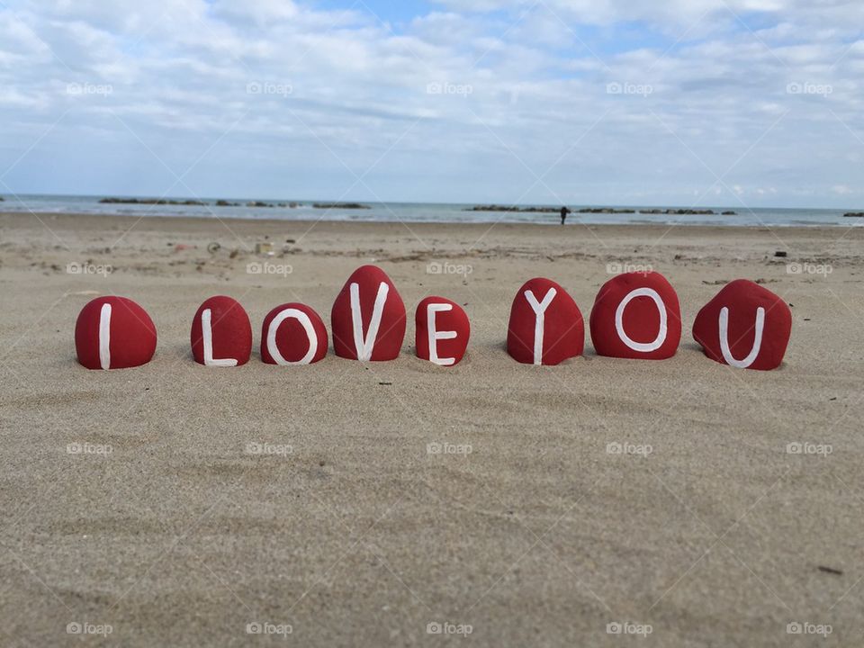 Red painted pebble on the beach