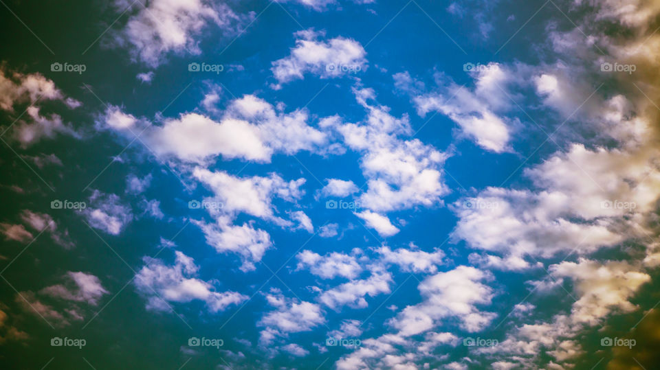 Large clouds float across the sunset sky like sails.