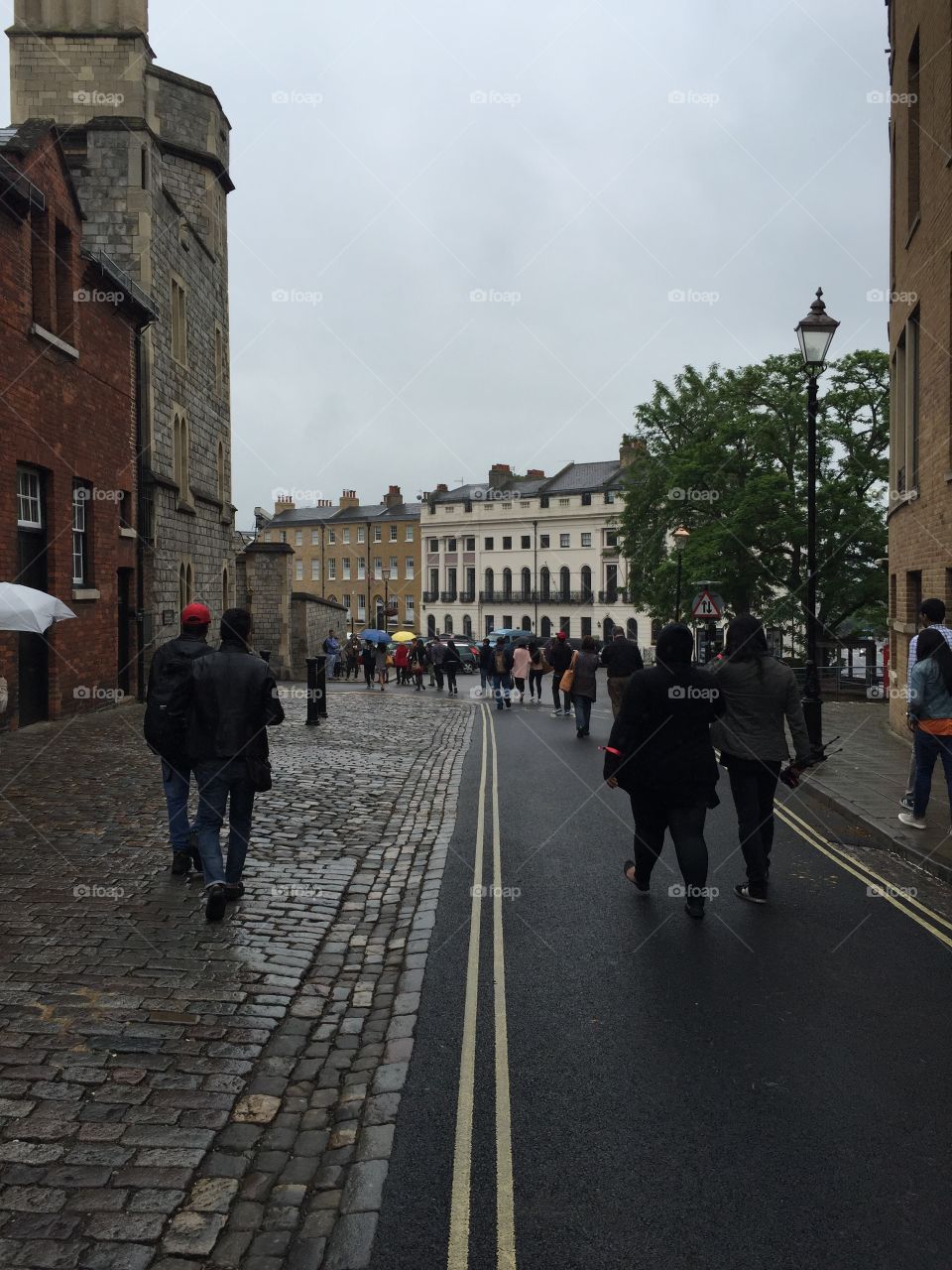 rainy, comfortable, cozy street in Windsor, England. Cloudy and gloomy with only a few spots of color, gorgeous cobblestone as well as pavement, historical buildings.