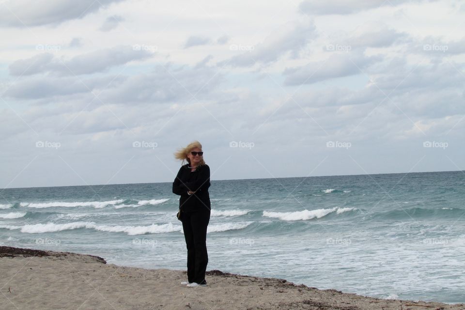 Mature woman standing near sea