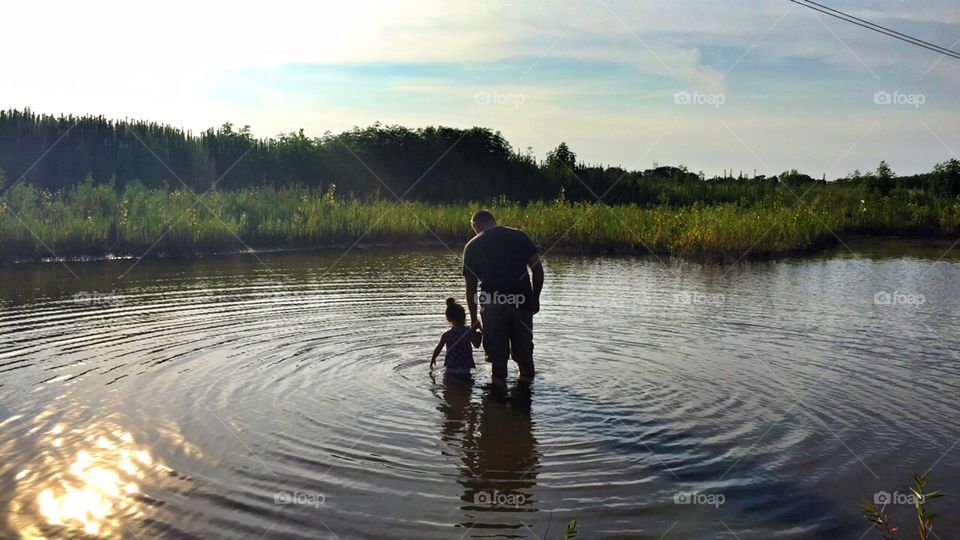 Daughter and father. . They decided to go swim in the pond. 