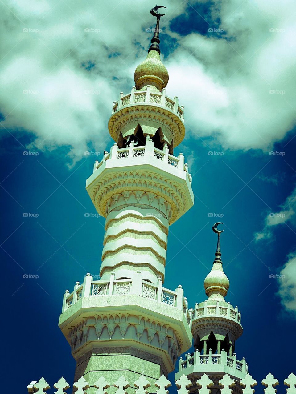 Mosque minarets touching the cloudy sky