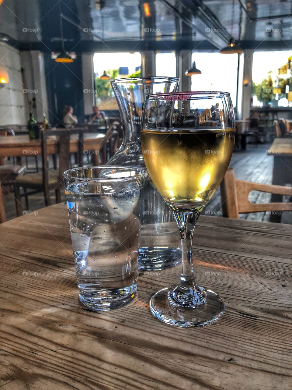Cold glass of white wine with a red lipstick mark in a pub in London, England.