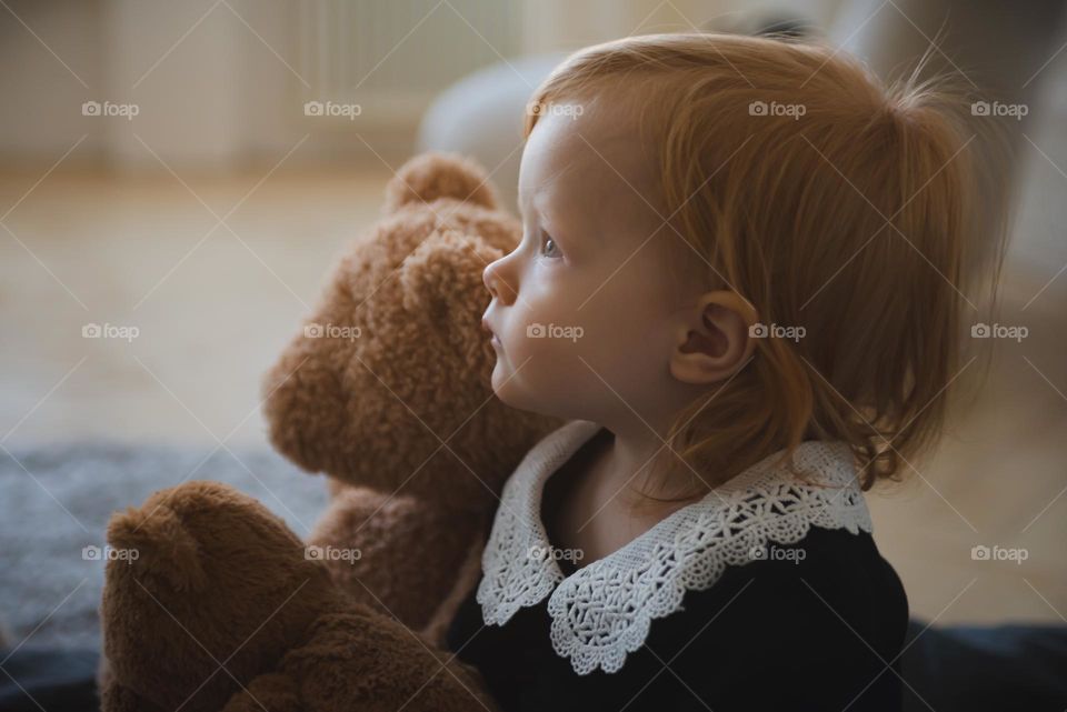 Little redhead girl with teddy bear