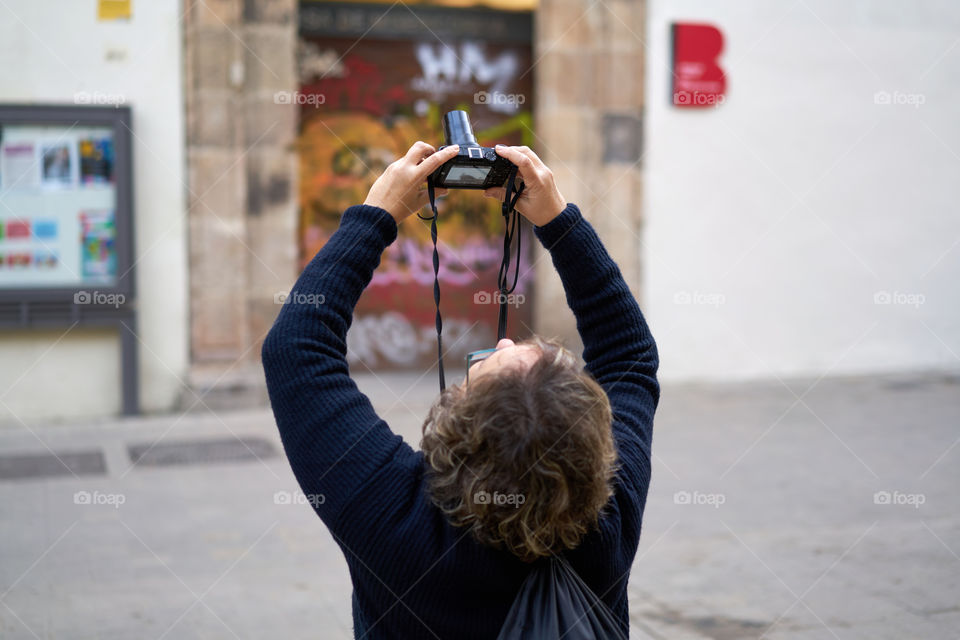 Rear view of a man photographing