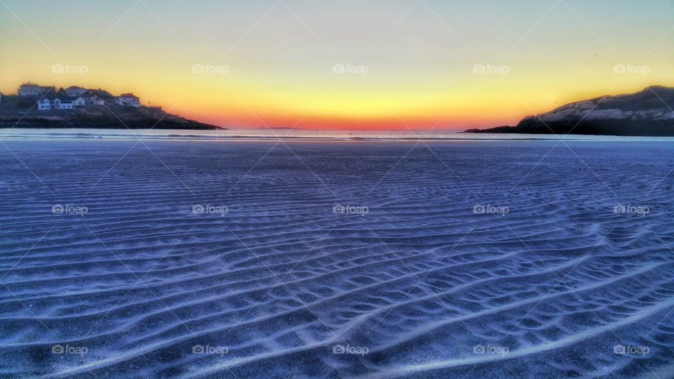 ripples. ripples in the sand with a beautiful sunrise and lighthouses as a backdrop