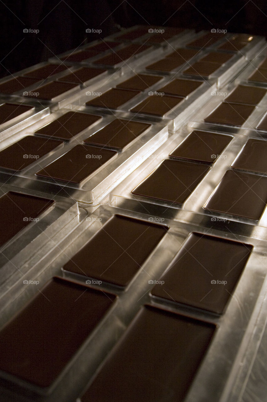 Chocolates. Bars of chocolate cover a table in a factory 