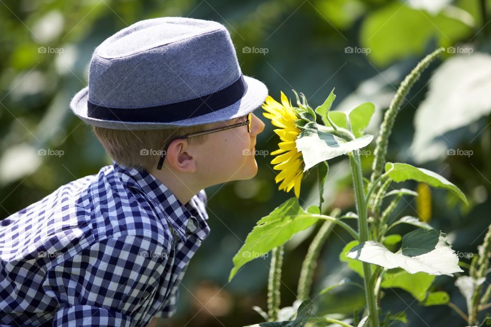 Just a trendy little side view of a hipster smelling flowers 