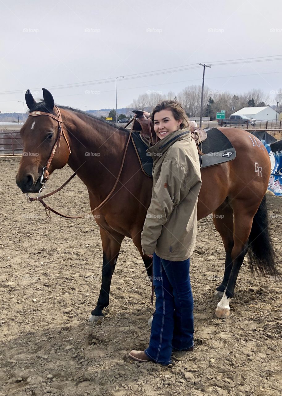 Brunette girl riding her bay quarter horse gelding. 