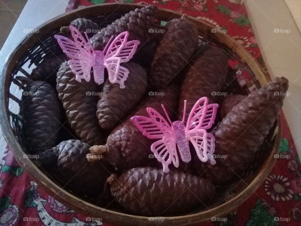 cesta con piñas, con detalles de mariposas.