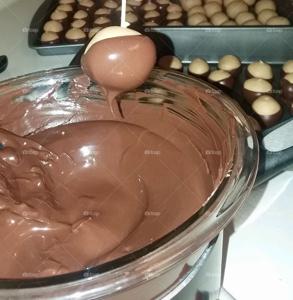 Making peanut butter buckeye desserts w melted chocolate 
