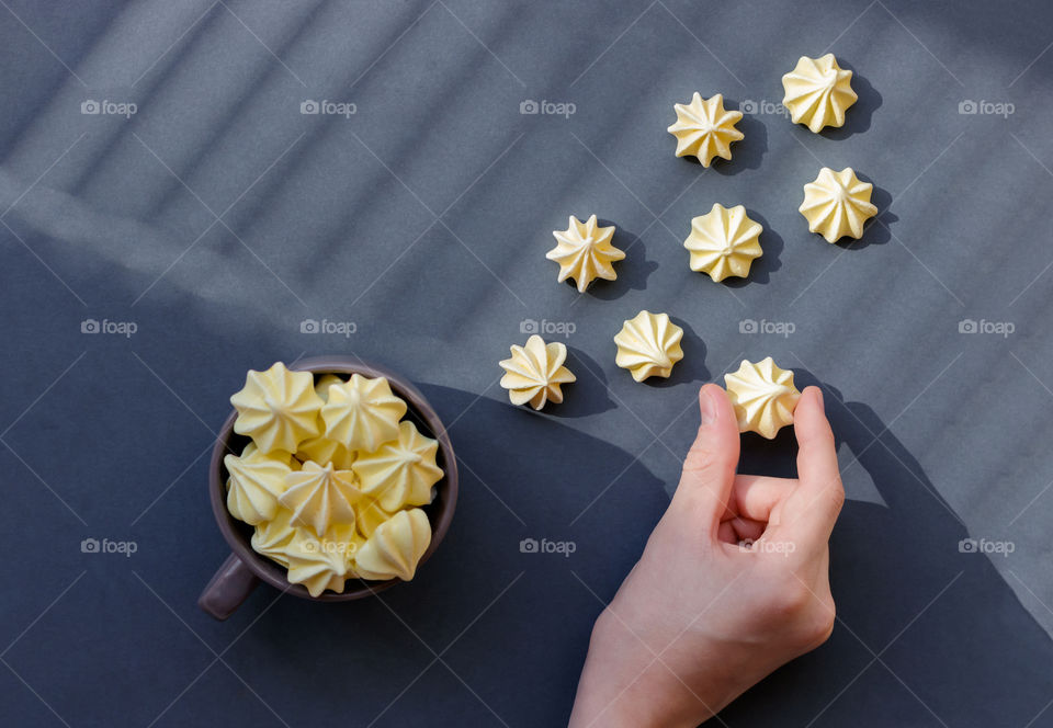 Top view to yellow meringue at gray background in a sunny hard light.