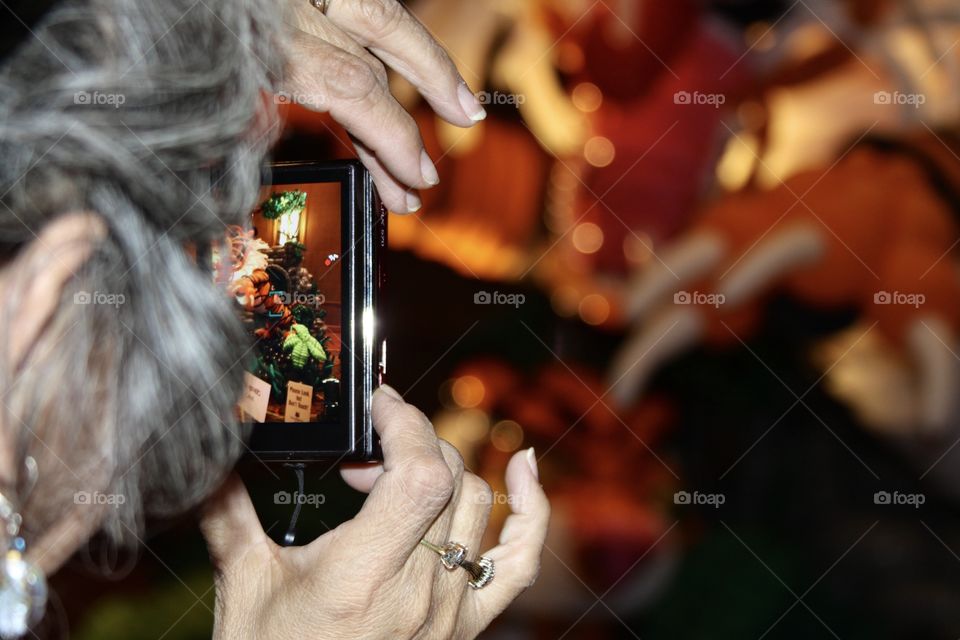 Older woman is taking a picture on her digital camera
