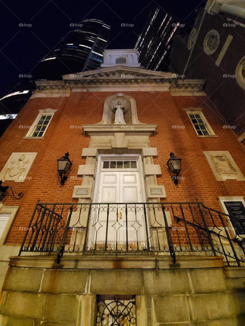 An old church dating back well over a hundred years sits as a testament to architectural craftsmanship in front of several modern steel and glass buildings