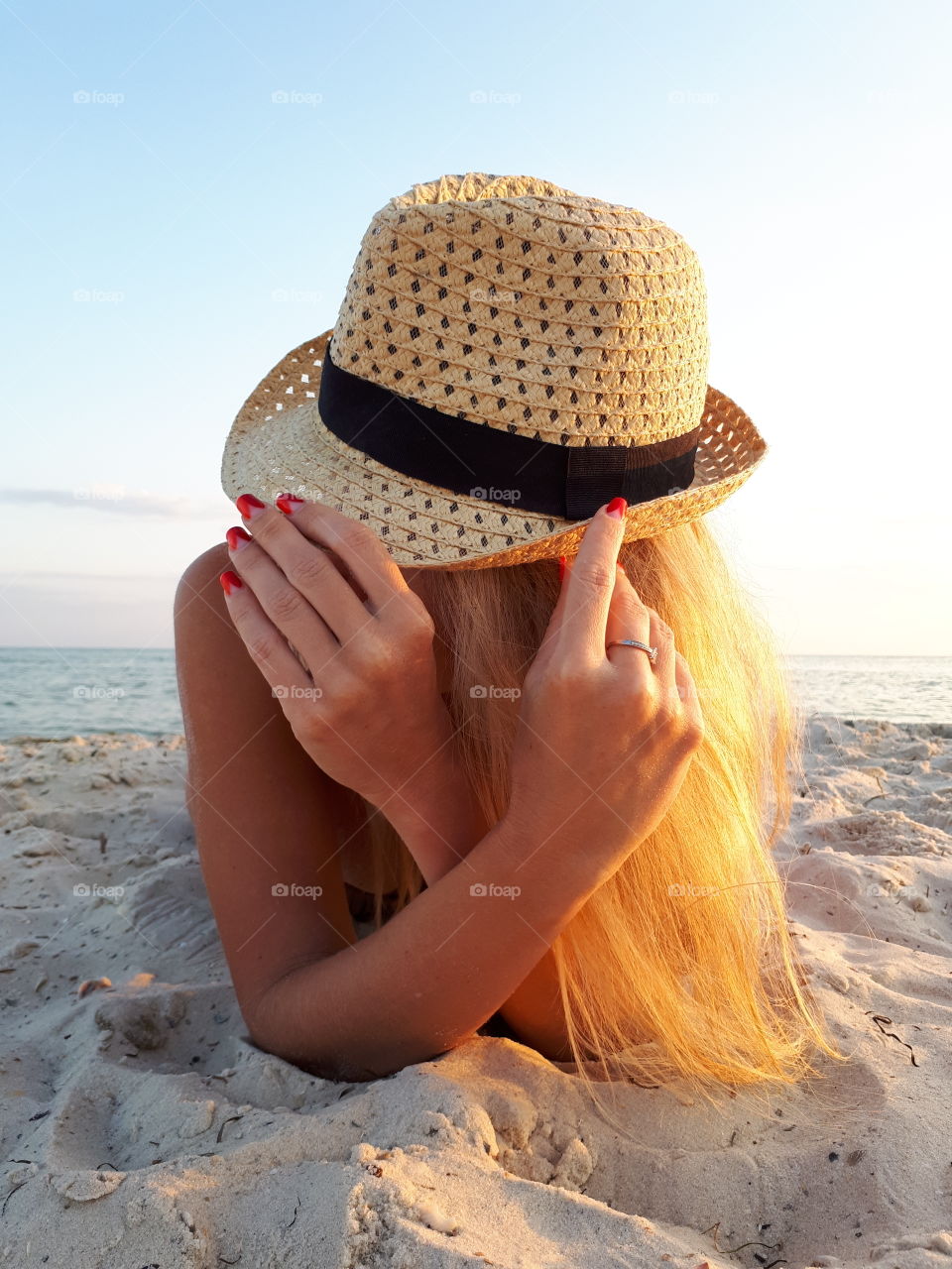 Woman with hat lying on the sand beach