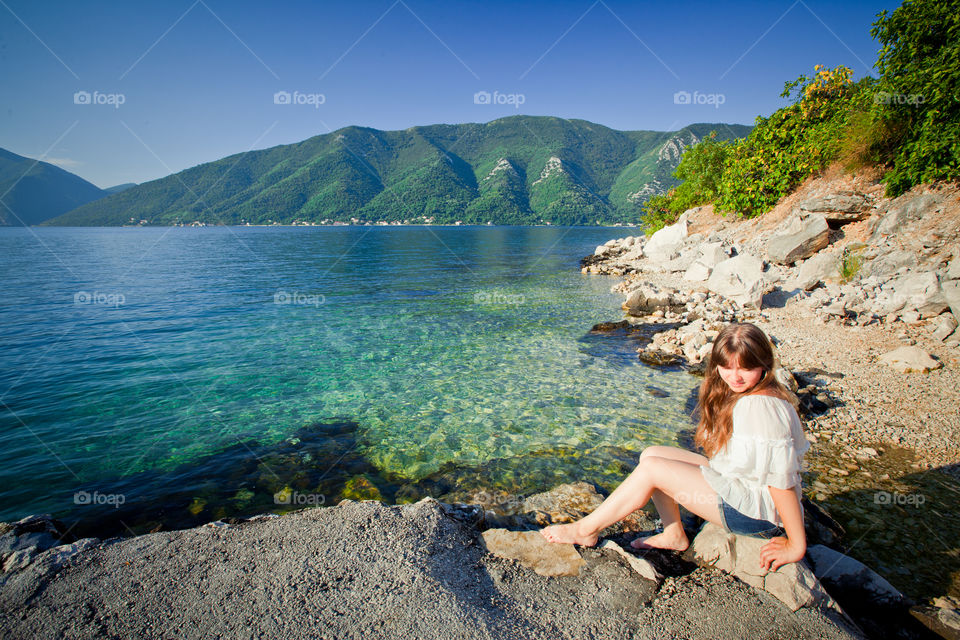 Young woman on the bay at sunrise