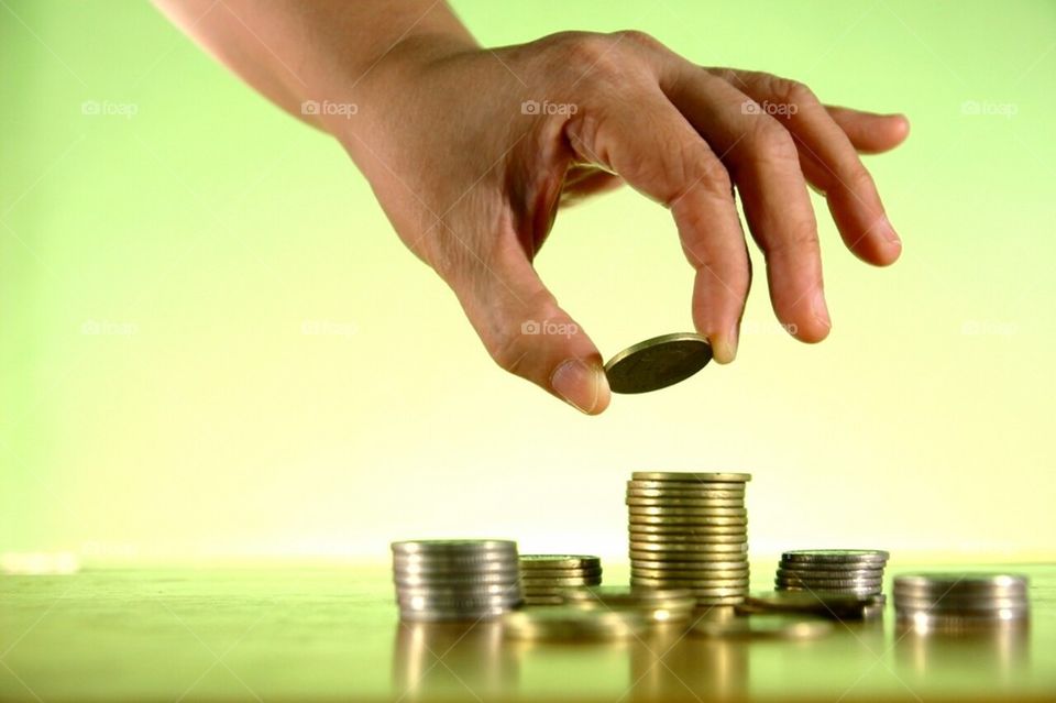 Hand stacking or piling coins