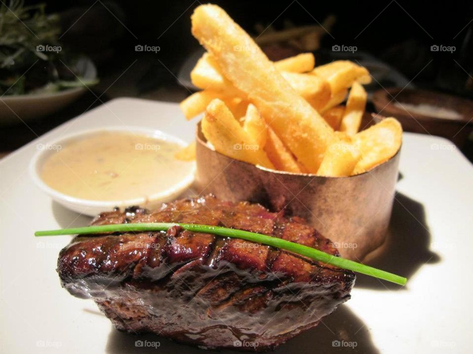 Delicious thick steak served with golden chips 