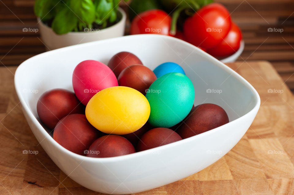 White square bowl full of colourful Easter eggs.