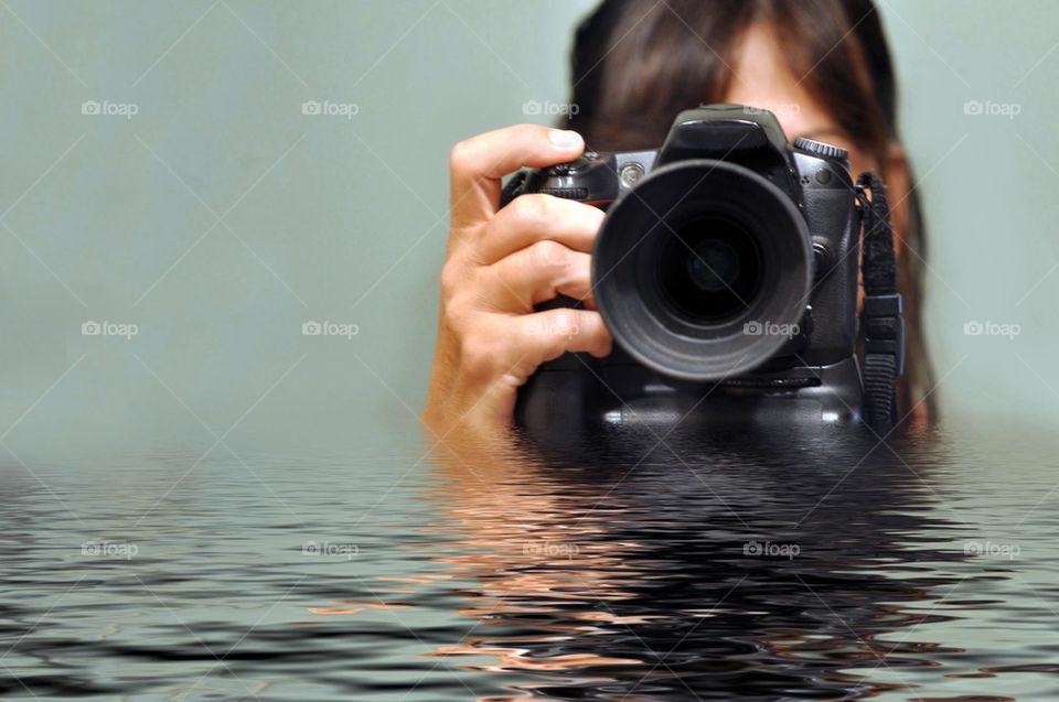 Woman taking photo standing in water 