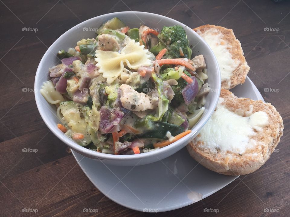 Bow tie pasta with chicken, zucchini, peppers, mushrooms, red onion, Brussels, asparagus, and carrots with garlic, pesto and Alfredo. Italian, garlic and cheese on a whole grain bun. A great spring and summer dish for lunch or dinner.