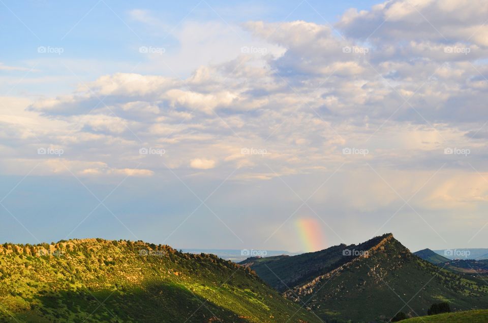 Cloudy sky against grassy mountain