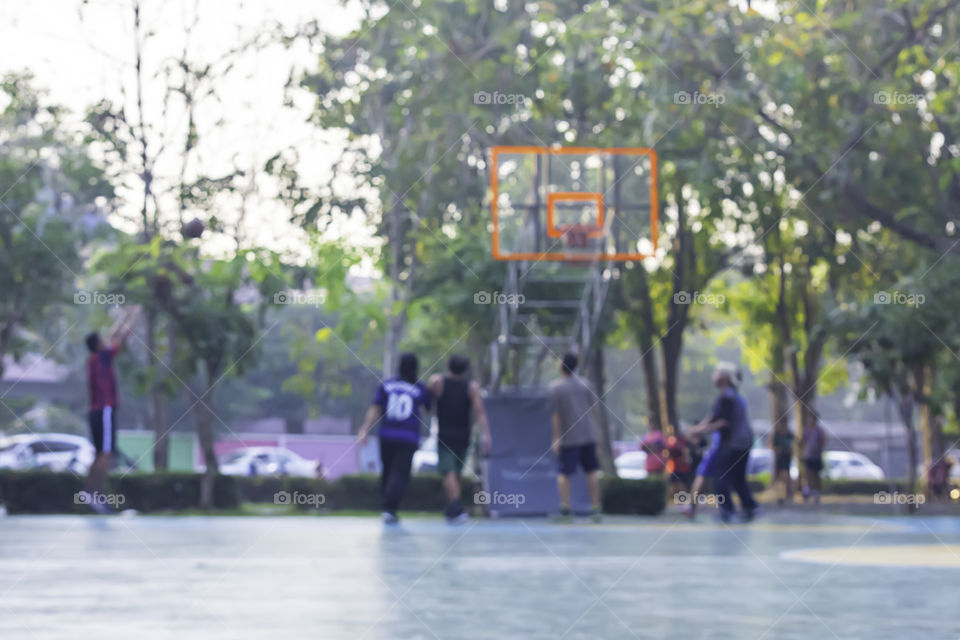 Blurry image of elderly men and women playing basketball in the morning.