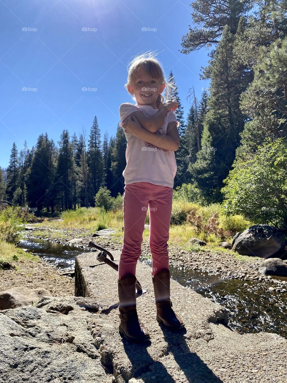 Little girl standing on rocks near a creek in Lake Tahoe