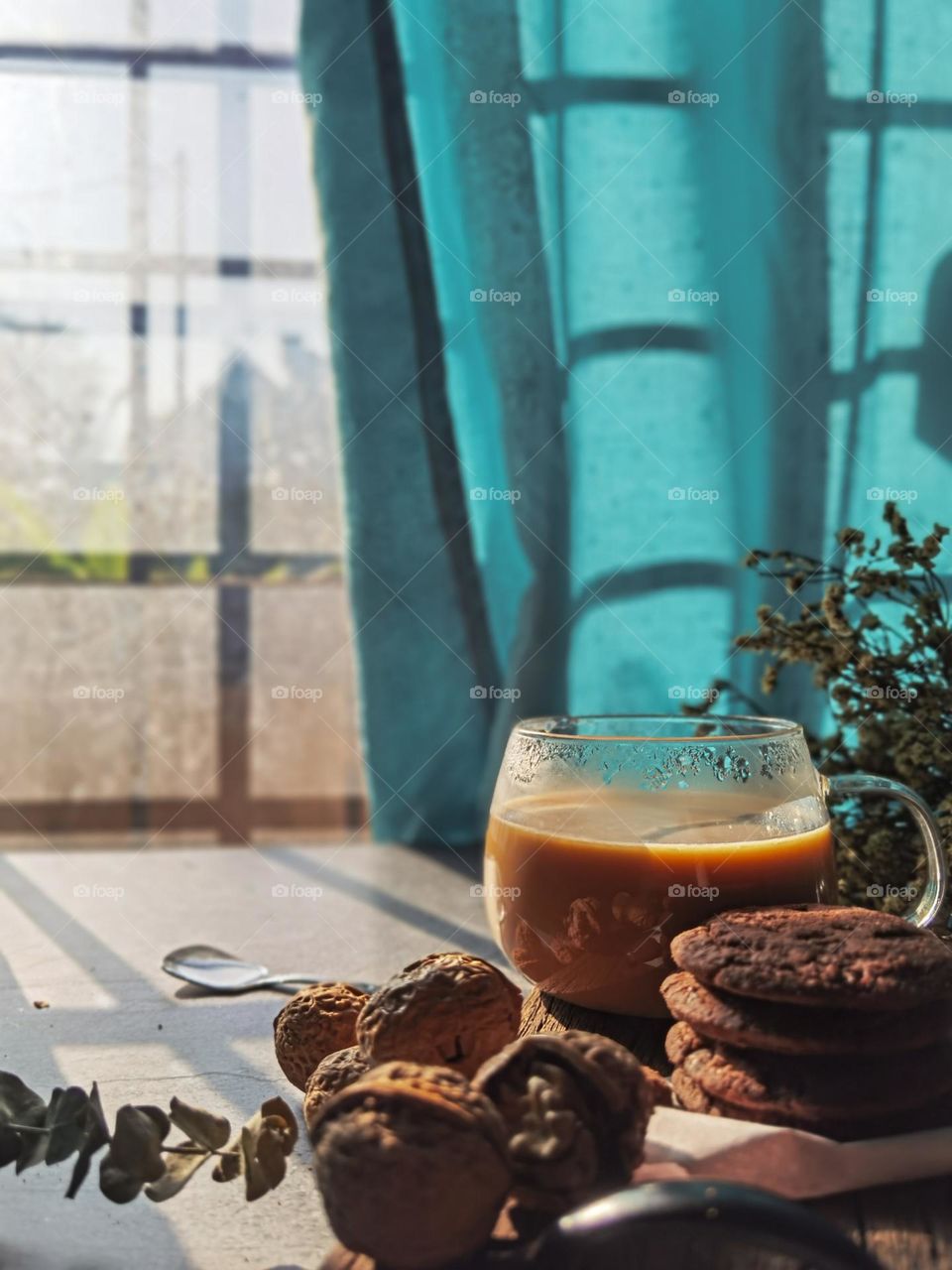 Hot cup of caffe latte and cookies by the window looking at the sunrise