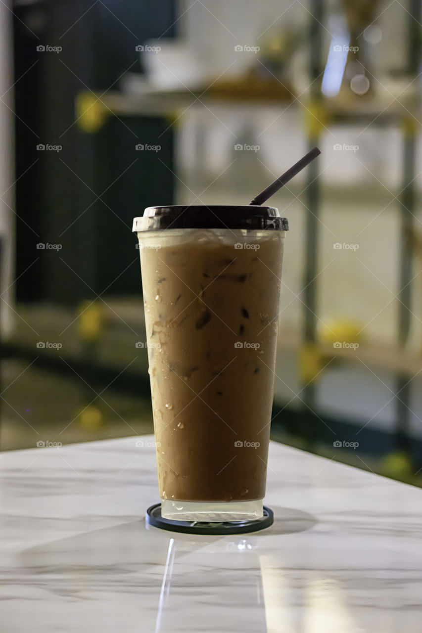 Iced coffee put whipped cream in a glass on the table.