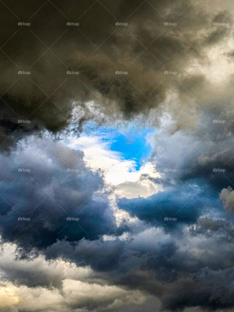 White clouds in the sky.  And dark clouds.  The sky is blue.  It is a very beautiful picture.