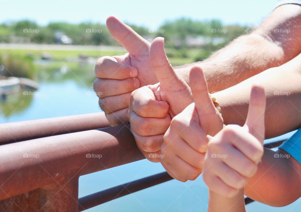 Family displaying thumbs up