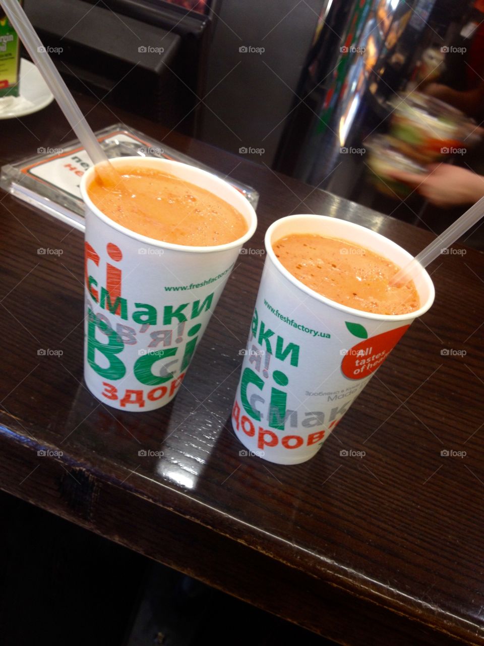 Fresh carrot orange juice in paper cup on a table