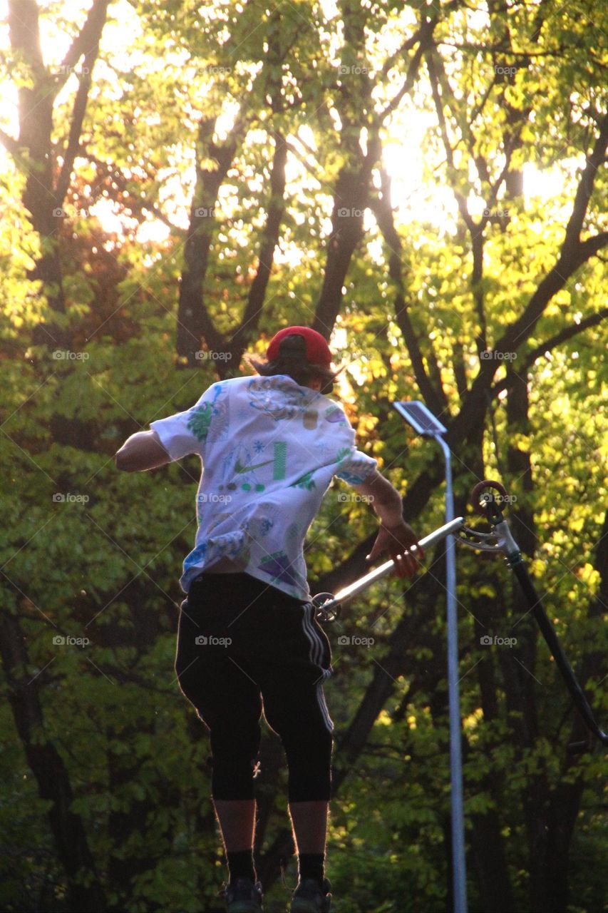 Boy in the air against the Sun background