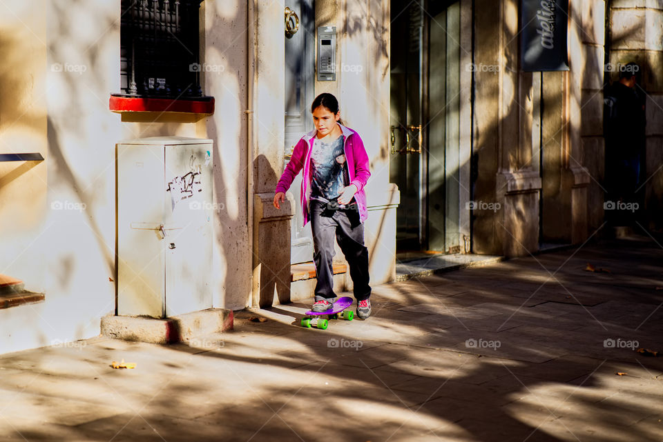 Patinando a la sombra de los árboles en un soleado mediodía. 