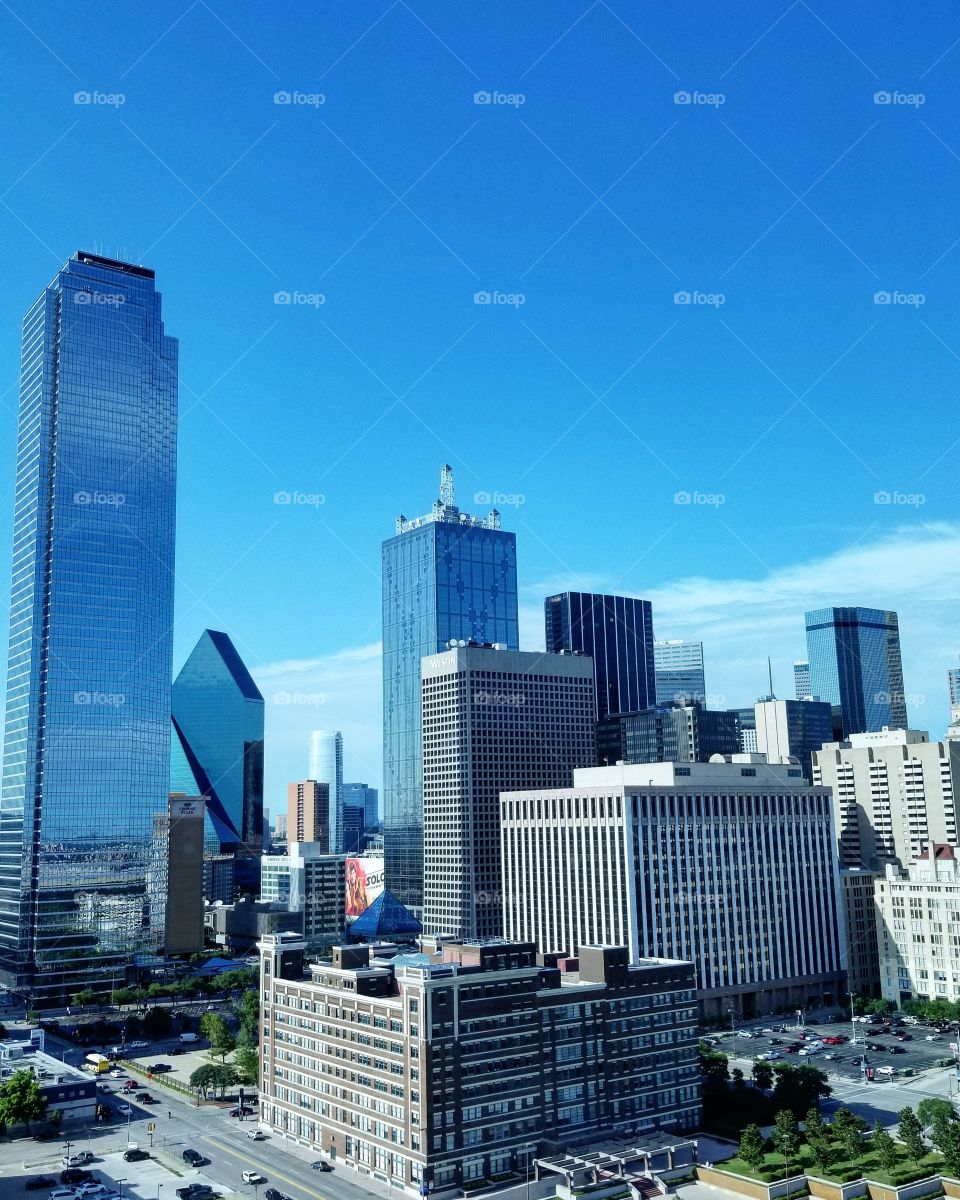 Skyline of downtown Dallas midday on a clear day with blue skies