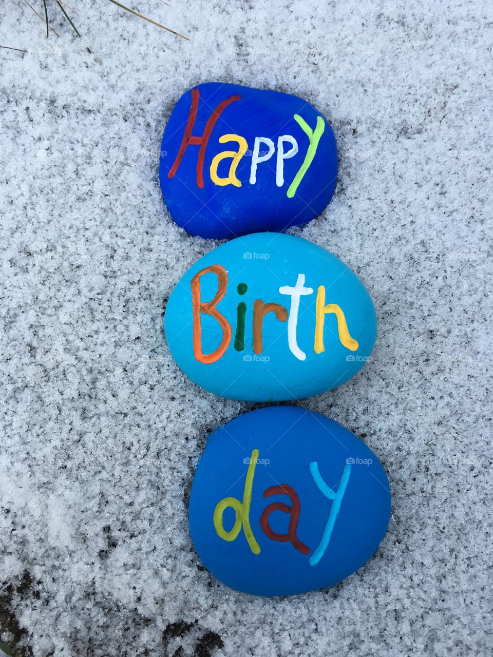 Happy Birthday on stones over the snow