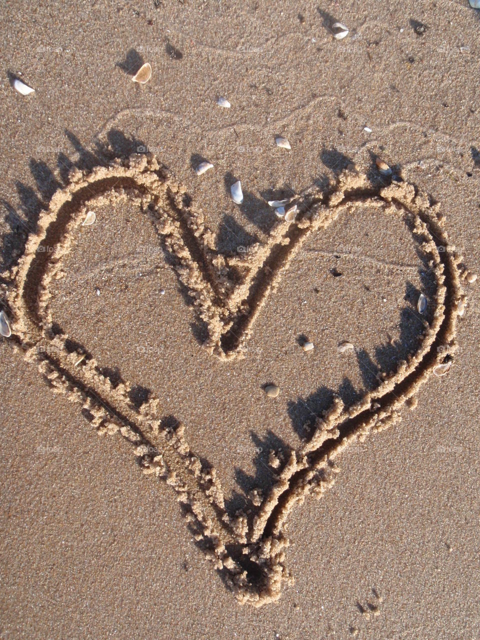 Heart in sand. Heart draw in wet sand at the beach