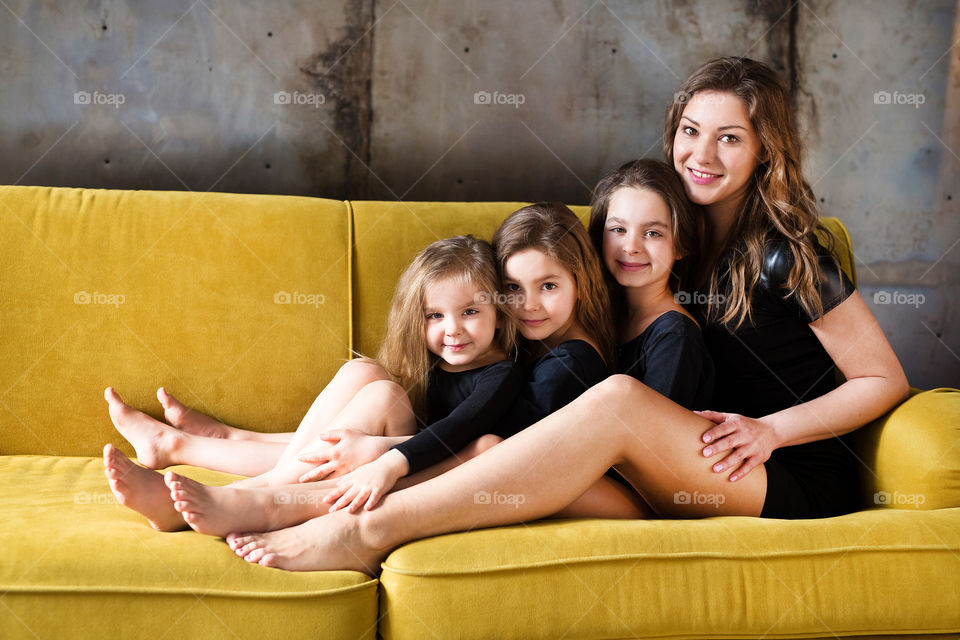 beautiful three sisters hug and laugh with mom