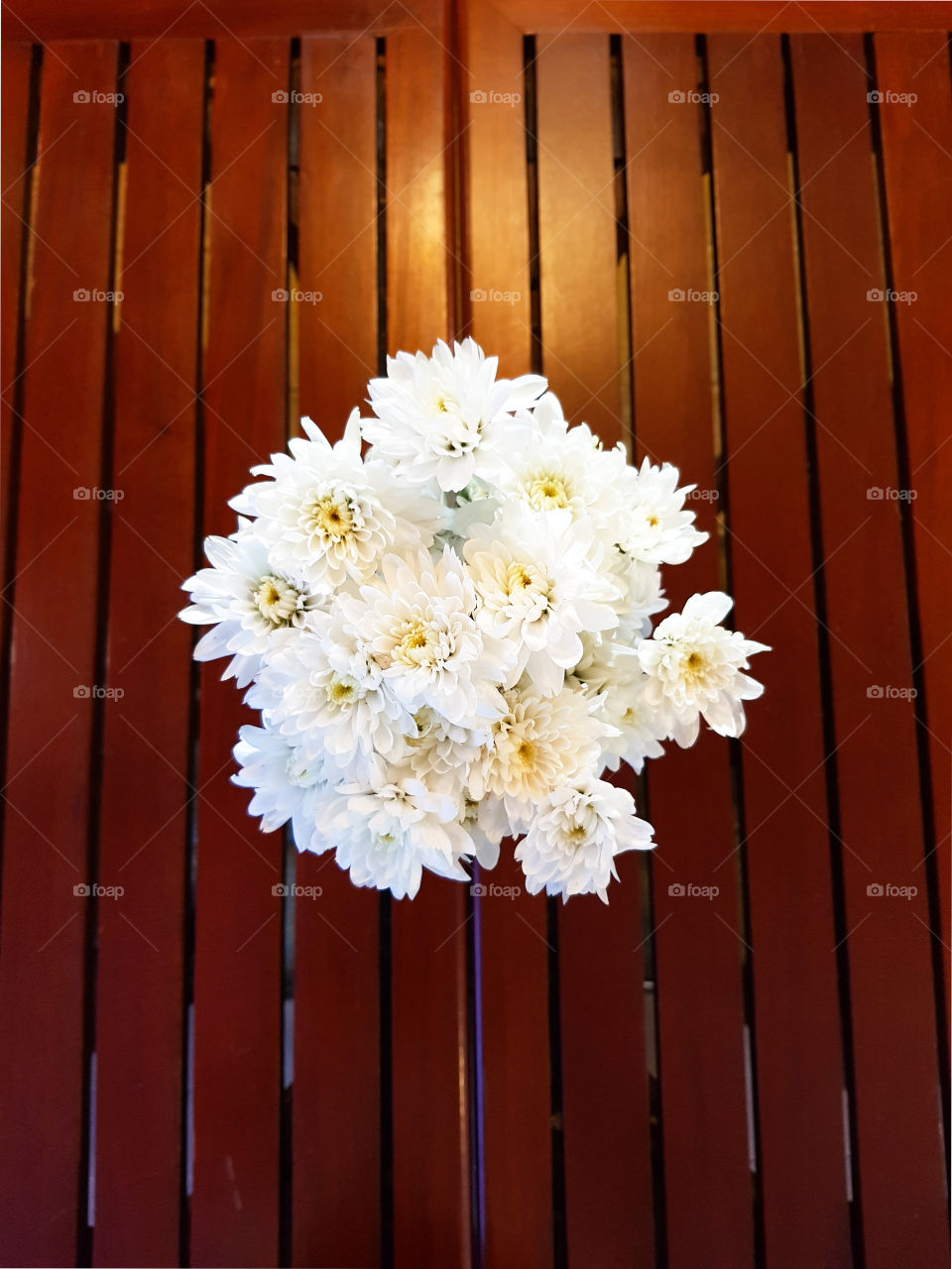 White fresh flower in a glass vase.It was put on wooden table for decoration.