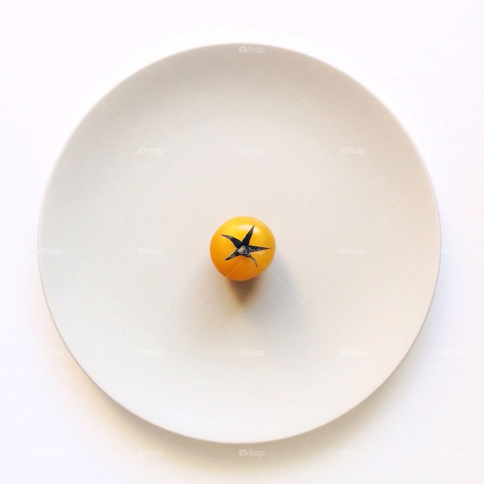 Yellow tomato on a white plate