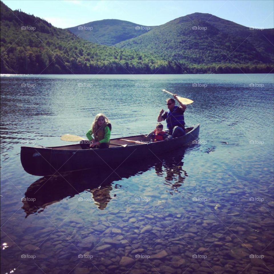 Family enjoying a calm canoe ride in the beautiful nature of Baxter State park in Northern Maine. 